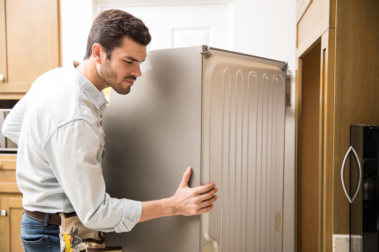 young-man-working-as-electrician-exposing-back-fridge-check-repair-it-scaled.jpg